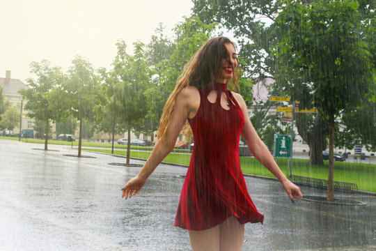 Happy woman dancing and smiling in the rain outside in wet red dress Stock  Photo | Adobe Stock