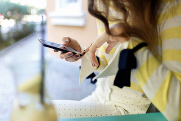 close-up of female hands with mobile phone printing sms or on the Internet