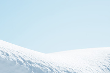 Fototapeta na wymiar Fresh snow background texture. Winter background with snowflakes and snow mounds. Blue sky