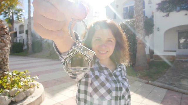 Happy young woman In Front of New Home with Keys