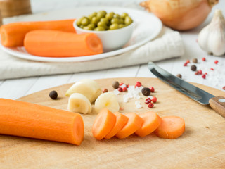 Sliced carrots on the table. Vegetables for cooking garlic peas onion peppers