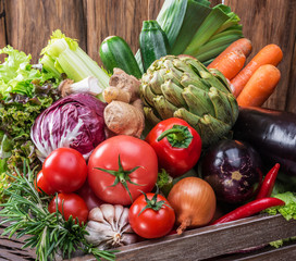 Fresh multi-colored vegetables in wooden crate. Top view.