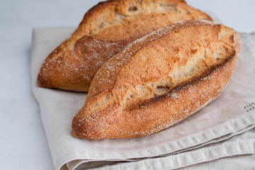 Different fresh bread, on white wooden table.