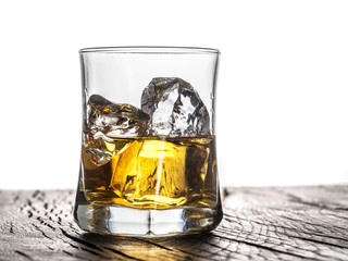 Whiskey glass or glass of whiskey with ice cubes on the table at white background.