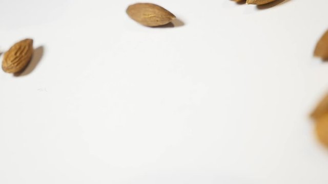 Almonds falling on white background