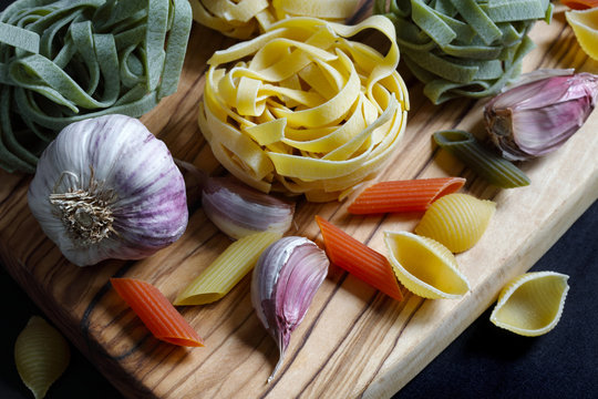 Close up Chiaroscuro Dark Food Pasta ingredients with spaghetti,  tagliatelle and penne tricolore and garlic