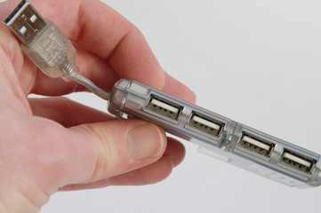 Hand holding a 4-port USB hub adapter (Universal Serial Bus)