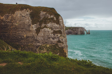 Colorful vertical limestone cliffs with sea coast  turquoise waters of the bay near Etretat in Normandy, France