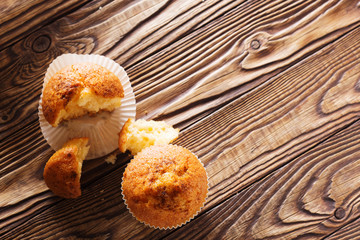Classic muffins on a wooden old background in a white wrapper.