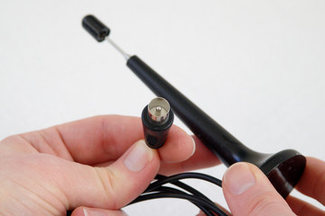 Hand holding Coaxial cable antenna connector of a DVB-T pig antenna