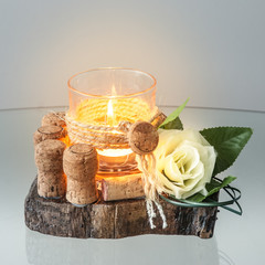 Decorative glass candle holder  on a piece of wood. Centerpiece on the table.