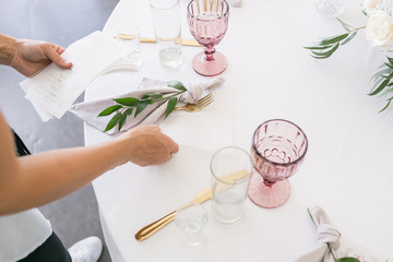 Beautiful table setting with crockery and flowers for a party, wedding reception or other festive event. Glassware and cutlery for catered event dinner.