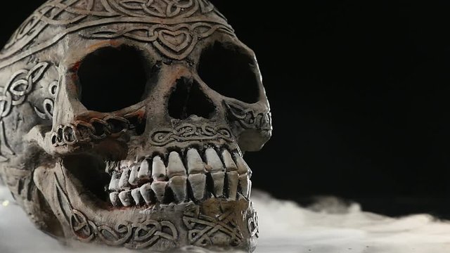 Skull covered in smoke on a dark background