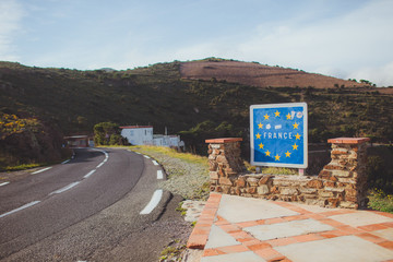 French border road sign with European Union blue flag and yellow stars between France and Spain...
