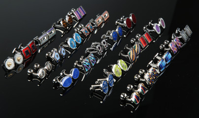 colorful cufflinks on the black and wooden background