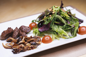 Salad with arugula and fried mushrooms and with liver