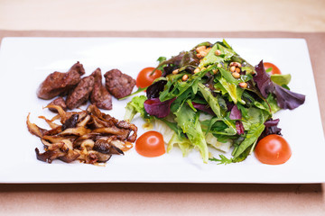 Salad with arugula and fried mushrooms and with liver
