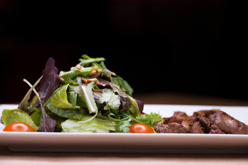 Salad with arugula and fried mushrooms and with liver