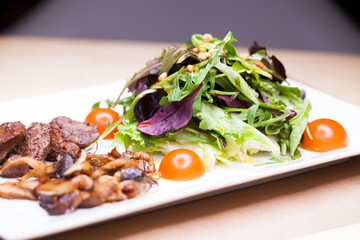 Salad with arugula and fried mushrooms and with liver