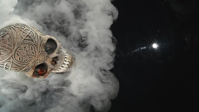 Skull covered in smoke on a dark background. top view