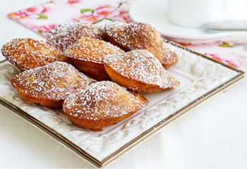 French cookies Madeleine and tea in white cup. Concept romantic Breakfast. Selective focus.