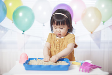 Fototapeta na wymiar baby girl play sand box at home