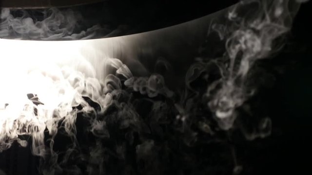 Close-up of ice smoke in bowl against black background
