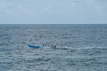 small wooden motorboat on ocean - people on boat -