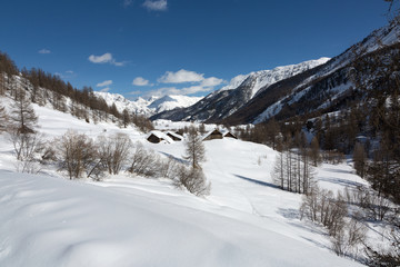 Fototapeta na wymiar Montagnes et chalets sous la neige - Nevache - Hautes-Alpes