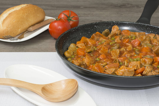 Carne guisada con tomates fritos y vegetales en una sarten