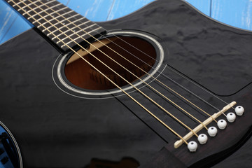 Fototapeta na wymiar Musical instrument - Black cutaway electric acoustic guitar blue wood background