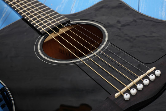 Musical instrument - Black cutaway electric acoustic guitar blue wood background