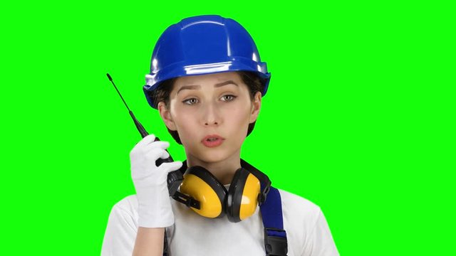 Bilder girl wearing wearing talks on the walkie talkie. Green screen. Close up