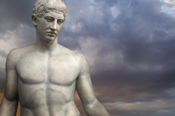 Greek Sculpture. Young Adonis bronze statue with blue sky background