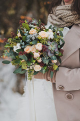 Beautiful winter bouquet of flowers in the hands of the bride 827.