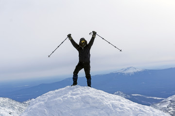 climber triumphs, reaching the top of the mountain