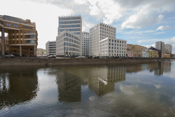 Fototapeta na wymiar Spring Moscow image. City is reflected in water of river