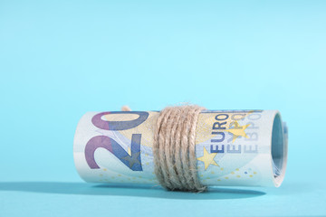 the Twenty Euro notes rolled over a blue background