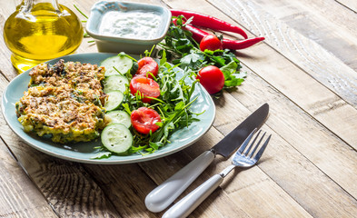 Juicy cutlets on a plate with a salad of tomatoes and arugula