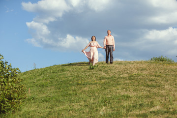 Young couple running on the grass.