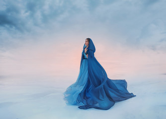 The Snow Queen in a blue raincoat that flutters in the wind. A traveler on a background of sunrise...