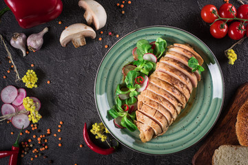 Chicken steak roasted and salad, food photography. Black background. Top view