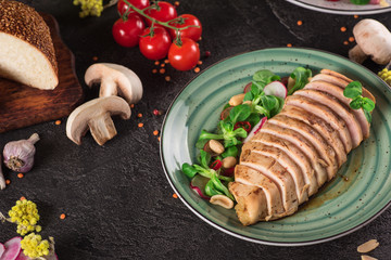 Chicken steak roasted and salad, food photography. Black background. Top view