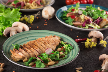 Chicken steak roasted and salad, food photography. Black background. Top view