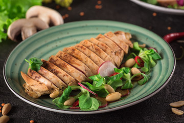 Chicken steak roasted and salad, food photography. Black background. Top view