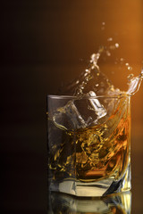 A Glass Of whiskey with ice and gold light