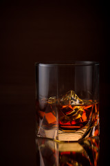 A Glass Of whiskey with ice and gold light