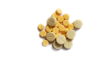 Closeup of yellow tablet on isolated white background. Tablets of different shapes and sizes....