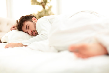 Obraz na płótnie Canvas closeup.the tired men sleep soundly on the bed
