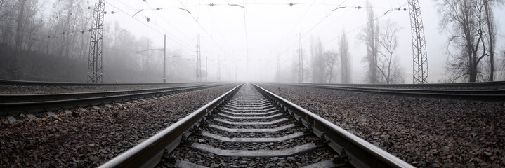 La voie ferrée dans un matin brumeux. Beaucoup de rails et de traverses s& 39 enfoncent dans l& 39 horizon brumeux. Photo fisheye avec distorsion accrue